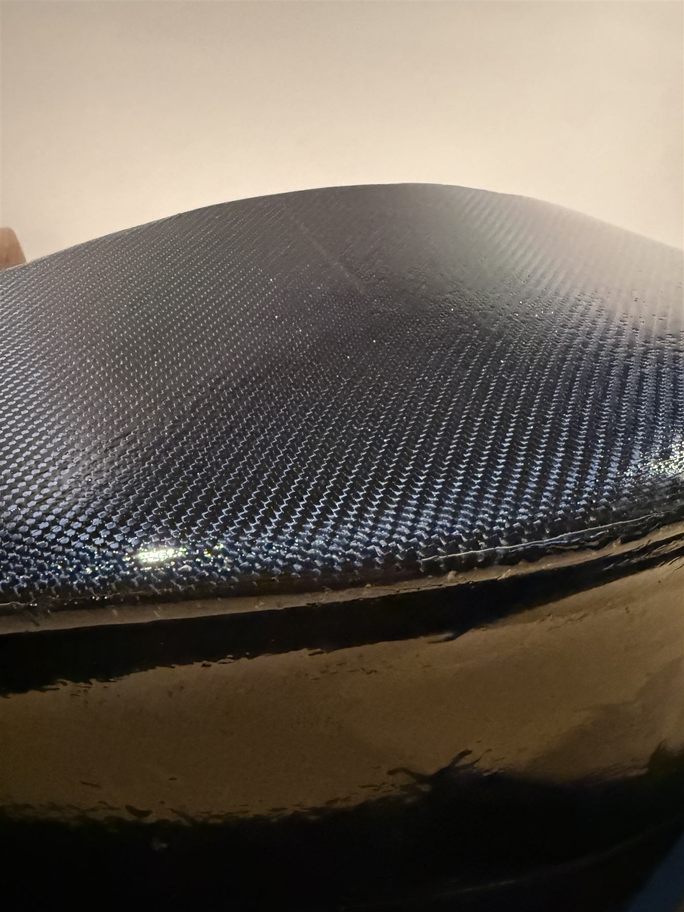 Finished 2x2 twill carbon-fiber weave, clear-coated